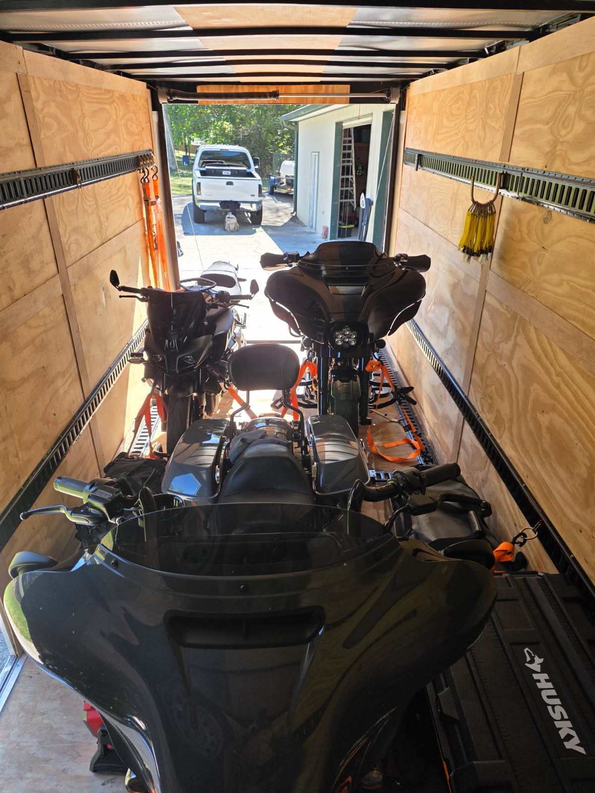 Interior of enclosed trailer showing motorcycles and watercraft secured