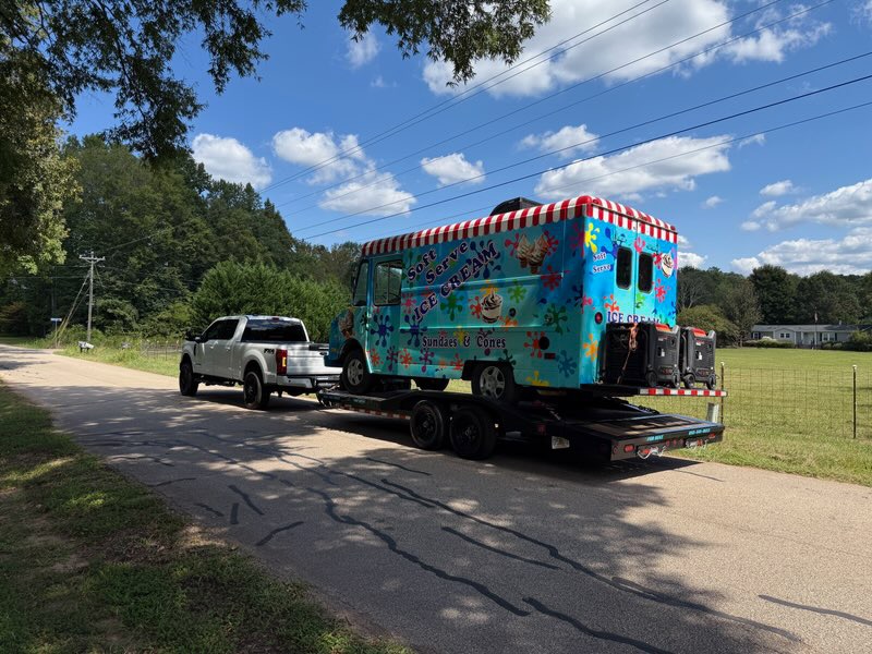 Ice cream truck being towed on rural road